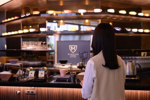 a woman standing at a counter in a restaurant at The Royal Park Canvas - Osaka Kitahama in Osaka
