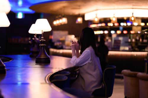 a woman sitting at a table in a casino at The Royal Park Canvas - Osaka Kitahama in Osaka