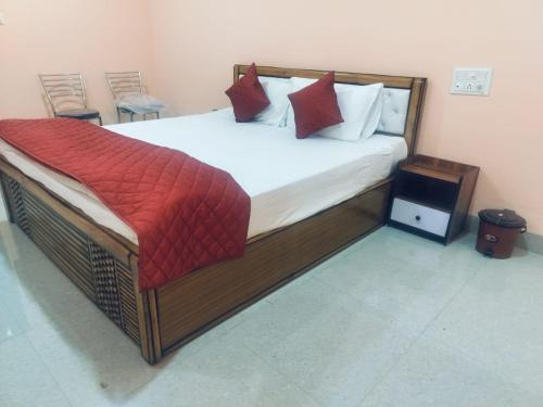 a bedroom with a large bed with red pillows at Hotel Golden Buddha Inn Bodhgaya in Bodh Gaya