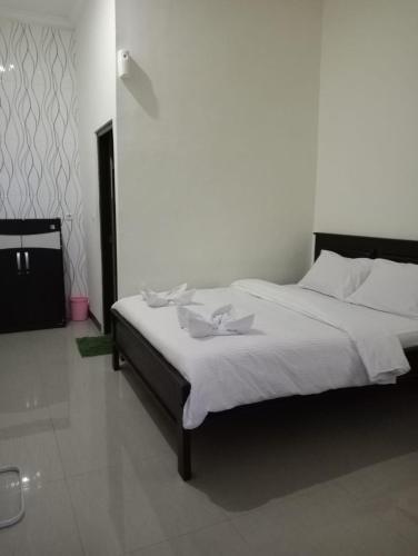 a bedroom with a large bed with white sheets at ESTEVANIA LODGE Kelimutu in Ende