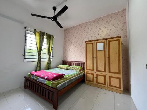 a small bedroom with a bed and a window at EL Homestay in Melaka