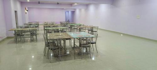 a group of tables and chairs in a room at Hotel Golden Buddha Inn Bodhgaya in Bodh Gaya