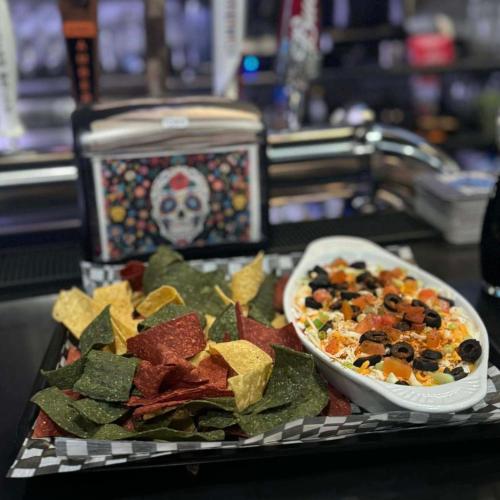 a plate of food with chips and a bowl of salsa at Anavada Inn & Suites - Prince George in Prince George