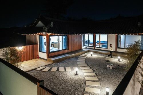 una casa con candele su un patio di ghiaia di notte di Gangneung Jeodong Hanok Pension newly built a Gangneung