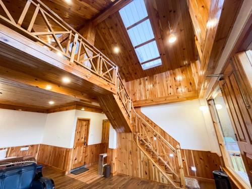 a staircase in a large room with wood paneling at Singing Woods Kutla in Kulu