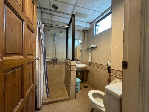 a bathroom with a toilet and a sink at Flora Place Hotel in Kota Bharu
