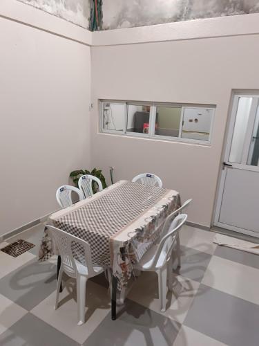 a white dining room with a table and chairs at Hospedaje J&B in Paso de los Libres
