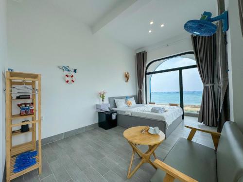 a bedroom with a bed and a table and a window at Dứa Homestay in Cu Lao Thu
