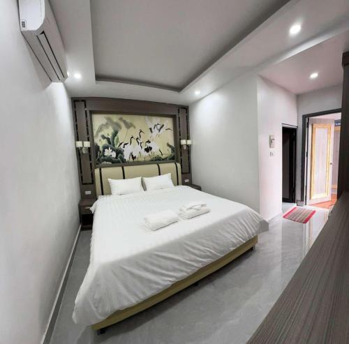 a bedroom with a large bed with two towels on it at Vang Vieng Rivercube Hotel in Vang Vieng
