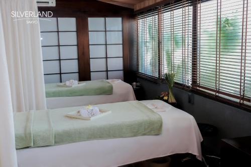 Ένα ή περισσότερα κρεβάτια σε δωμάτιο στο Silverland Sakyo Hotel