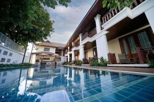 a swimming pool in front of a house at Athena Hotel in Pakse