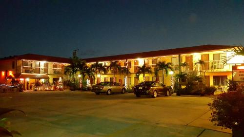 two cars parked in a parking lot in front of a building at Lago Motor Inn in Lake Worth