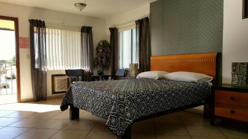 1 dormitorio con 1 cama con manta blanca y negra en Lago Motor Inn, en Lake Worth