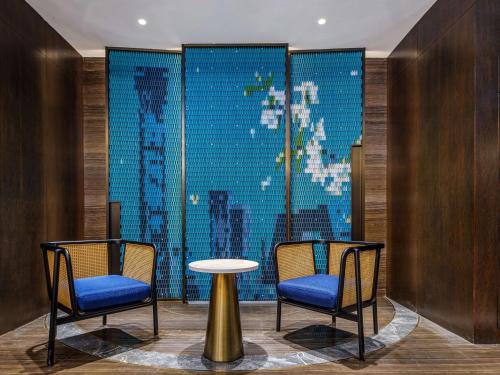 two chairs and a table in front of a window at Hilton Garden Inn Beijing Guomao in Beijing