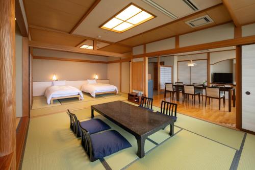 a room with two beds and a dining room at Ikkyu -Seaside Hotel- in Tsuruoka