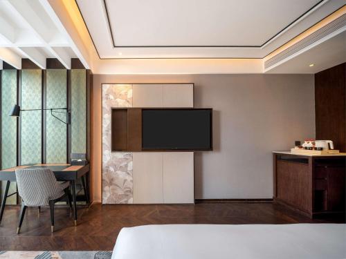 a hotel room with a television and a dining room at Hilton Garden Inn Beijing Guomao in Beijing