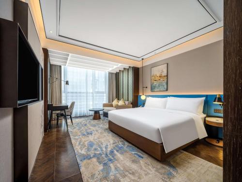 a hotel room with a bed and a television at Hilton Garden Inn Beijing Guomao in Beijing
