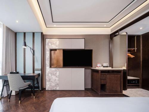 a hotel room with a television and a dining room at Hilton Garden Inn Beijing Guomao in Beijing