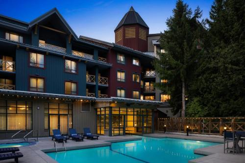an exterior view of a hotel with a swimming pool at Delta Hotels by Marriott Whistler Village Suites in Whistler