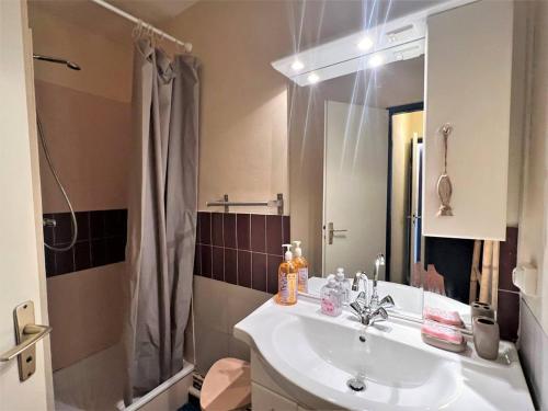 une salle de bain avec un lavabo blanc et une douche dans l'établissement Studio Cabine Centre-Ville, Parking & Animaux Acceptés - FR-1-307-274, à La Grande Motte