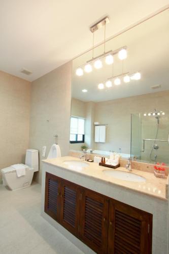 a large bathroom with a large sink and a toilet at The Grand Napat in Chiang Mai