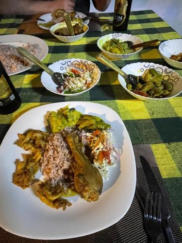 a plate of food on a table with plates of food at lake paradise cabana in Tissamaharama