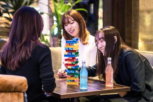 two women sitting at a table with bottles of alcohol at The Royal Park Canvas - Osaka Kitahama in Osaka