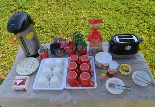 una mesa de picnic con comida y bebida y una licuadora en NiNo San Glamping - Pak Chong, en Pak Chong