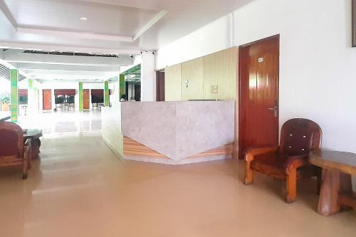 a hallway with a table and chairs in a building at Urbanview Hotel Cendrawasih Lahat By RedDoorz in Muaraenim