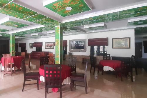 a dining room with red tables and chairs at Urbanview Hotel Cendrawasih Lahat By RedDoorz in Muaraenim