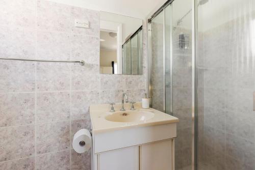 a bathroom with a sink and a shower at Glory House at Culburra - Beachfront in Culburra Beach