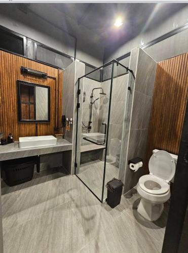 a bathroom with a shower and a toilet and a sink at Black Sheep House Khaoyai by ALPHATEL PARTNER in Pong Talong