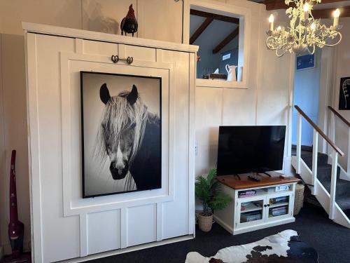 a picture of a horse on a wall in a living room at The Cottage at The Willows in Cambridge