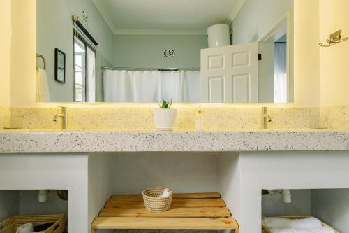 ein Badezimmer mit einer Theke und einem großen Spiegel in der Unterkunft Sarita Village Homes in Arusha