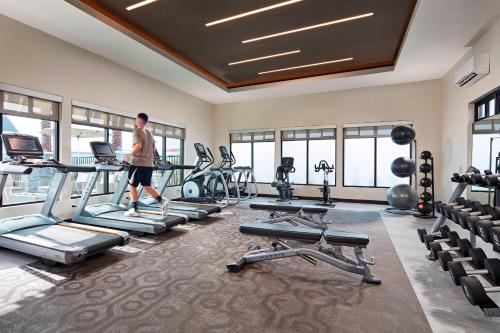 a man walking through a gym with treadmills and machines at Residence Inn Los Angeles LAX/Manhattan Beach in Manhattan Beach