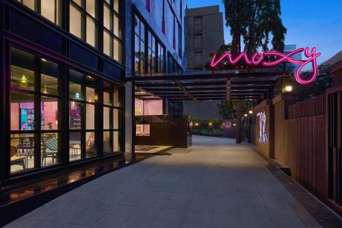 an empty street with a neon sign on a building at Moxy Mumbai Andheri West in Mumbai