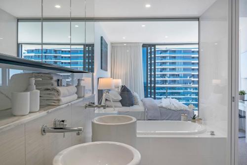 a white bathroom with two sinks and a tub and a window at MEGA VIEWS at Oracle - level 32 in Gold Coast