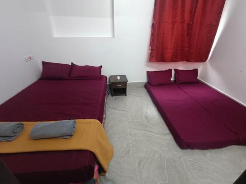 two beds in a room with purple sheets at Omkara - The Fives Guest house in Tiruvannāmalai