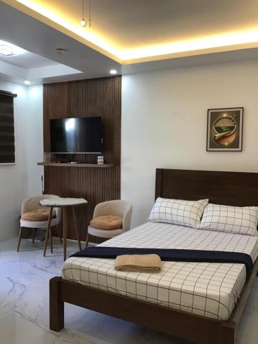 a bedroom with a bed and a flat screen tv at Agateahs Place mini beach resort in Olongapo