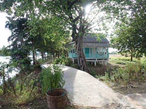 una casa blu con un albero di fronte di Bontai Riverside Cottages & Long-Stay Residences a Don Det