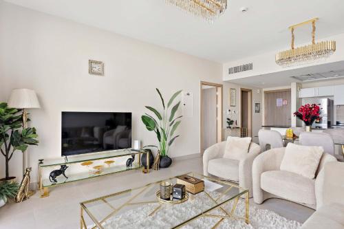 a living room with a large tv and a couch and chairs at Silkhaus Premium 1BR at Soho Square in Saadiyat in Abu Dhabi