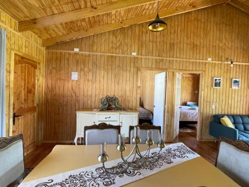a dining room with a table and a bedroom at Comodidad y Hermosa Vista Volcán in Melipeuco