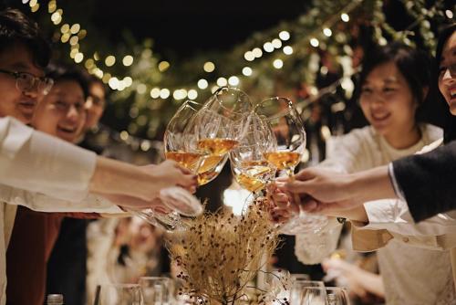 a group of people holding up glasses of wine at YiXi Designer Hotel - Xi'an Bell Tower & Ming City Wall & T'ang Dynasty Ever-Bright City in Xi'an