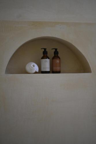 two bottles ofodorizers sitting on a shelf in a bathroom at Mayava Villa in Ahangama
