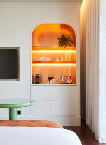 a room with a white cabinet with a tv at The Standard, Bangkok Mahanakhon in Bangkok