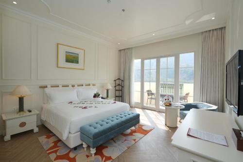 a bedroom with a large white bed and a television at Legend Valley Hotel Ha Nam in Phủ Lý
