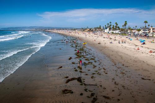 a beach with a lot of people and the ocean at Newly Renovated 3BR Modern Apt in Heart of Ocean Beach in San Diego