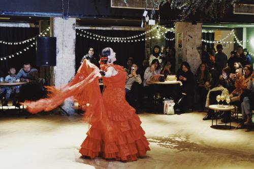 a woman in an orange dress dancing on a stage at YiXi Designer Hotel - Xi'an Bell Tower & Ming City Wall & T'ang Dynasty Ever-Bright City in Xi'an
