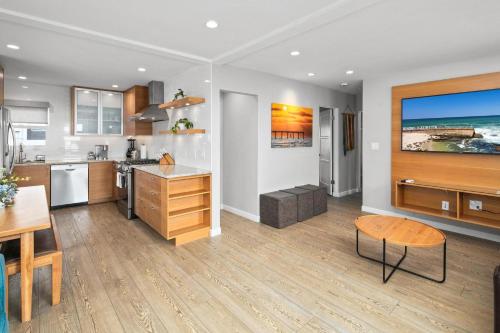 a kitchen and dining room with a table and a counter at Newly Renovated 3BR Modern Apt in Heart of Ocean Beach in San Diego