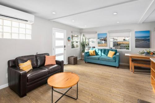 a living room with a couch and a table at Newly Renovated 3BR Modern Apt in Heart of Ocean Beach in San Diego